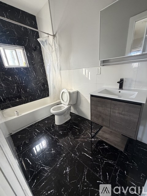 A bathroom with a toilet, sink, and mirror.