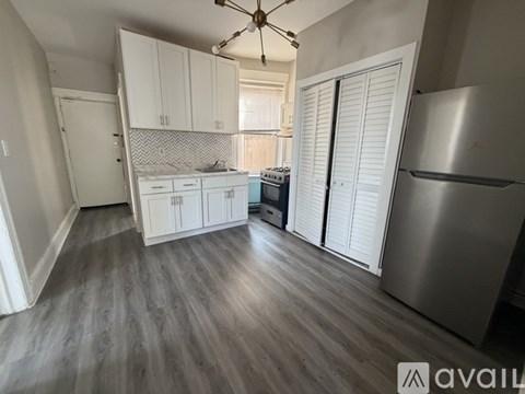 A kitchen with white cabinets and a stainless steel refrigerator.