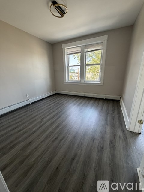 A room with wooden flooring and a window.
