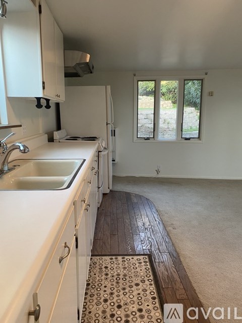 A kitchen with white cabinets and a sink.