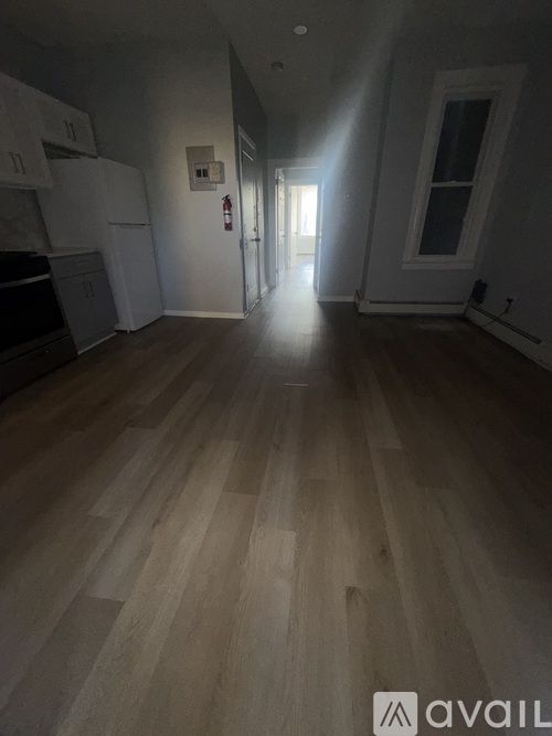A long hallway with wooden floors and white walls.