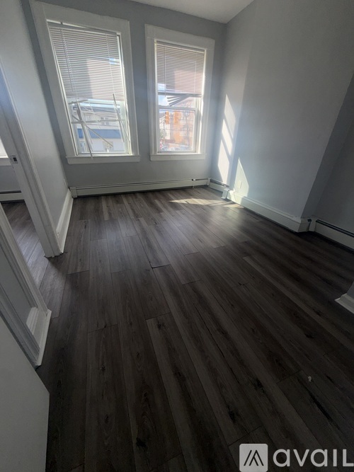 A room with wooden flooring and a window.