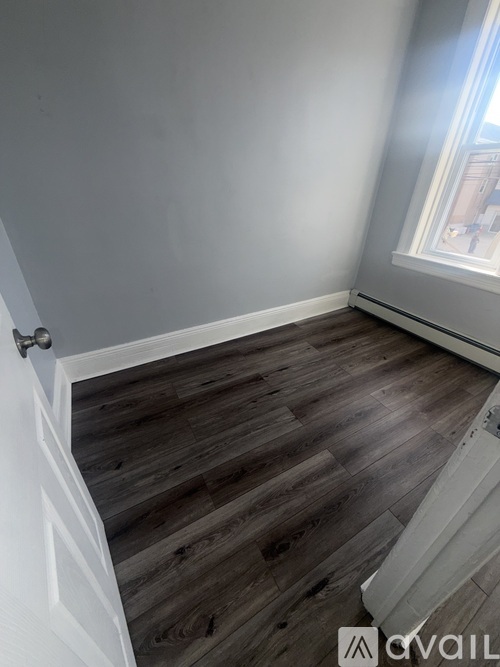 A room with wooden flooring and a white door.