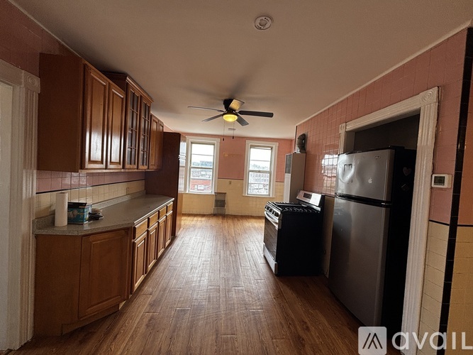 A kitchen with wooden cabinets and a ceiling fan.