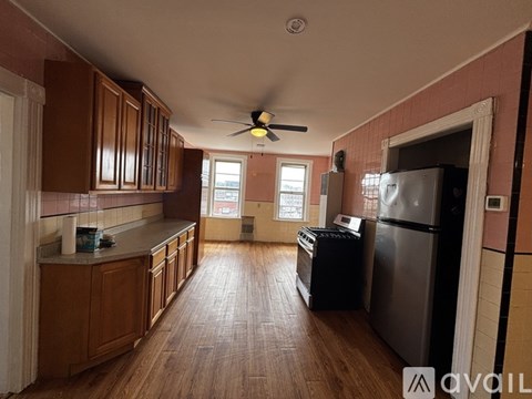 A kitchen with wooden cabinets and a ceiling fan.