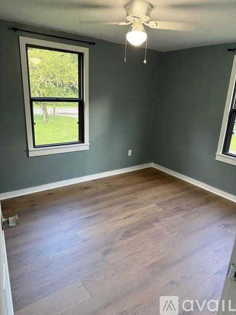 A room with a window and wooden flooring.