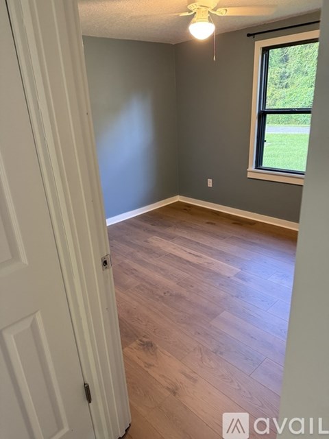 A room with wooden flooring and a window.