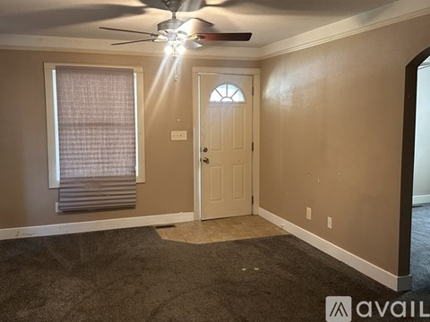 A room with a ceiling fan and a door.