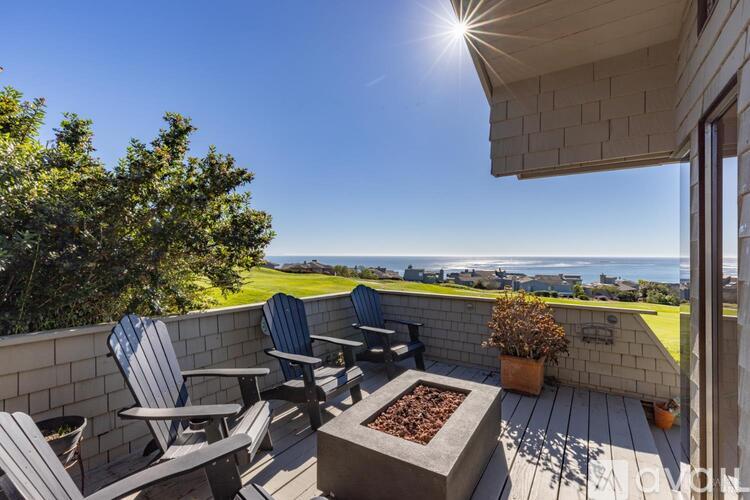 A sunny patio with chairs and a fire pit.