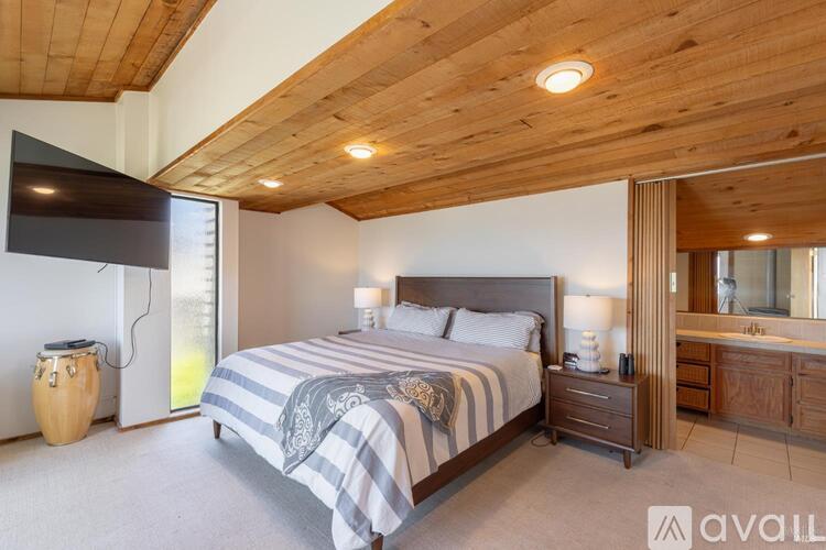 A bedroom with a bed, nightstand, and a drum.