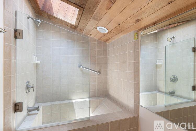A bathroom with a glass shower door and a glass door to a toilet.