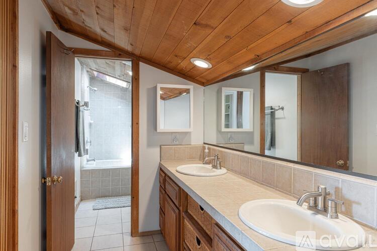 A bathroom with a wooden ceiling and a white sink.