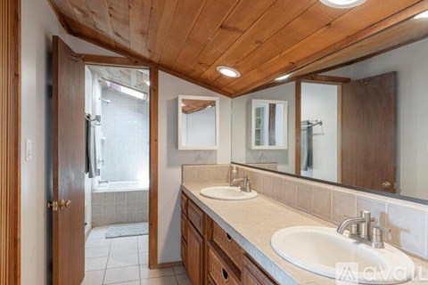 A bathroom with a wooden ceiling and a white sink.