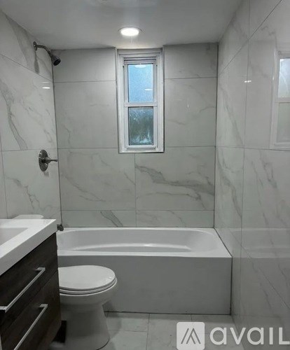 A bathroom with a marble wall and a window.
