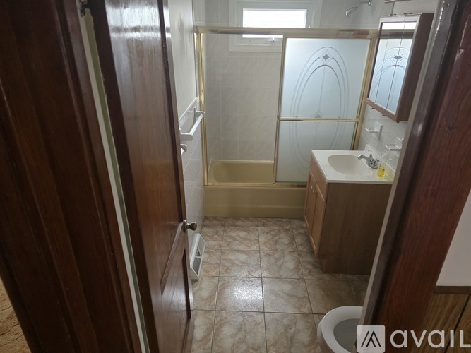 A bathroom with a glass shower door and a sink.