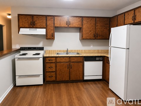 A kitchen with wooden cabinets and white appliances.