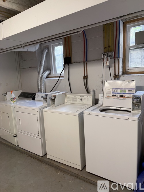 A white washing machine and dryer are on a concrete floor.