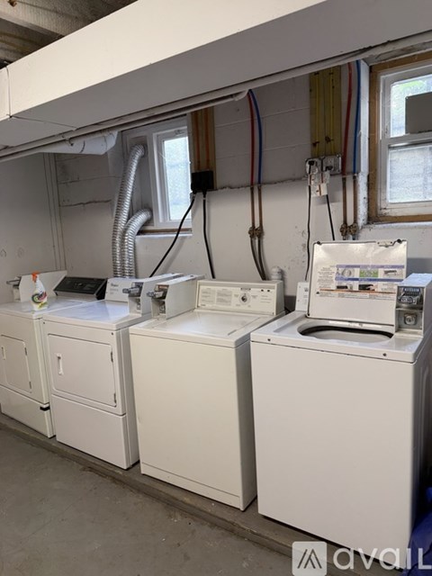 A white washing machine and dryer are on a concrete floor.