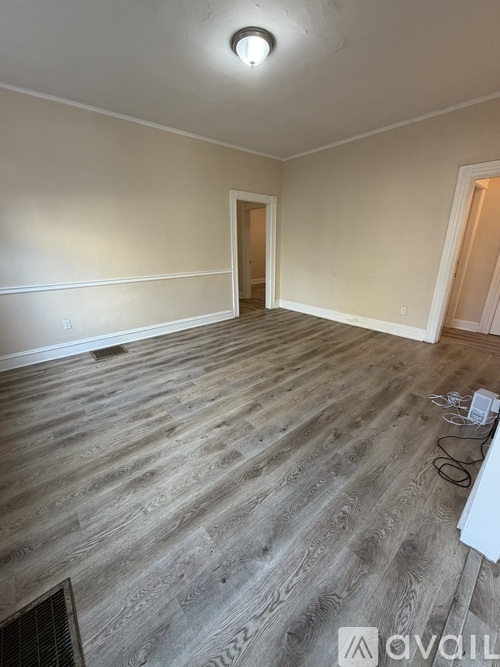 A room with wooden flooring and a single light fixture on the ceiling.
