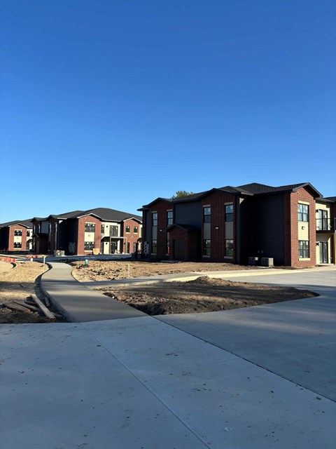 A row of new houses with a concrete pathway in front.