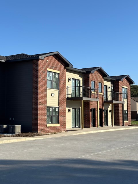 A row of red brick houses with a clear blue sky in the background.