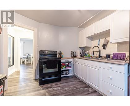 A kitchen with white cabinets and a black oven.