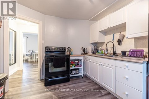 A kitchen with white cabinets and a black oven.