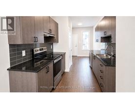 A modern kitchen with dark countertops and wooden cabinets.