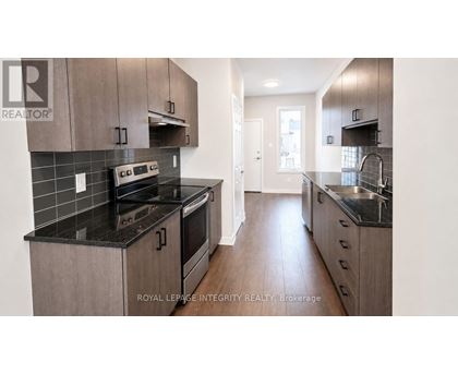A modern kitchen with dark countertops and wooden cabinets.