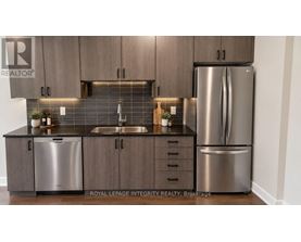 A kitchen with a sink, dishwasher, and refrigerator.