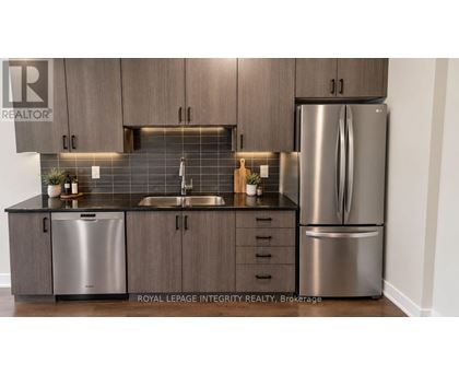 A kitchen with a sink, dishwasher, and refrigerator.