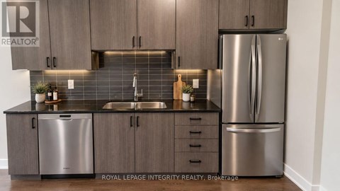 A kitchen with a sink, dishwasher, and refrigerator.