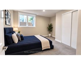 A bedroom with a bed, a window, and a plant.