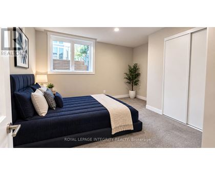 A bedroom with a bed, a window, and a plant.