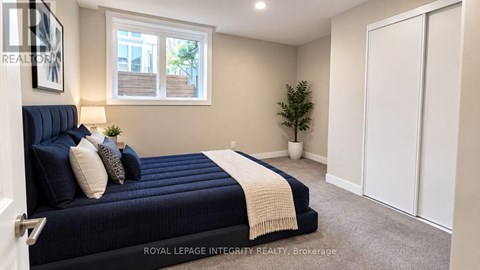 A bedroom with a bed, a window, and a plant.