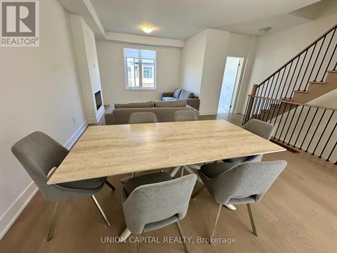 A dining room with a wooden table and chairs.
