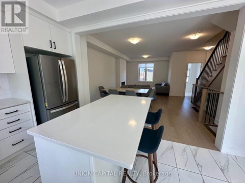 A kitchen with a white countertop and a stainless steel refrigerator.
