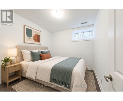 A bedroom with a bed, nightstand, and a painting on the wall.