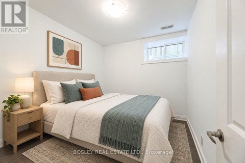 A bedroom with a bed, nightstand, and a painting on the wall.