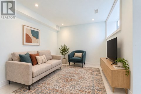 A living room with a couch, chair, and television.