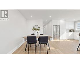 A dining room with a table and chairs.