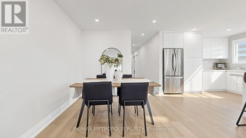 A dining room with a table and chairs.