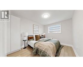 A bedroom with a bed, lamp, and a window with blinds.