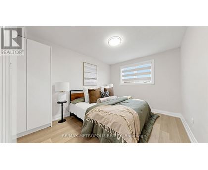 A bedroom with a bed, lamp, and a window with blinds.