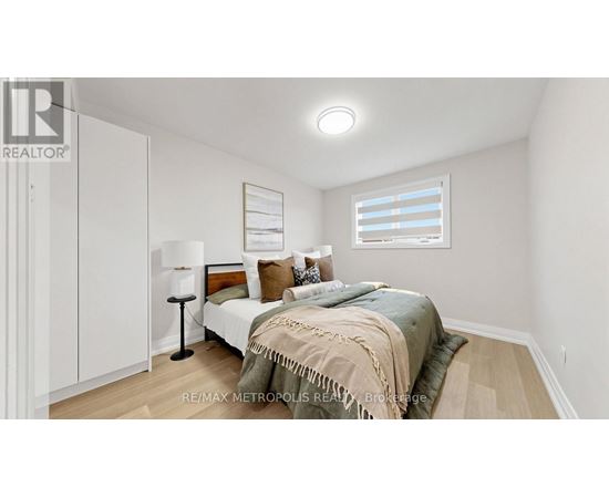 A bedroom with a bed, lamp, and a window with blinds.