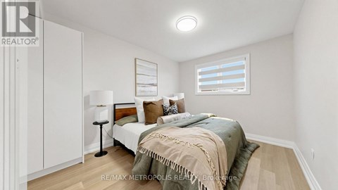 A bedroom with a bed, lamp, and a window with blinds.