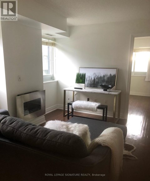 A living room with a couch, a television, and a fireplace.