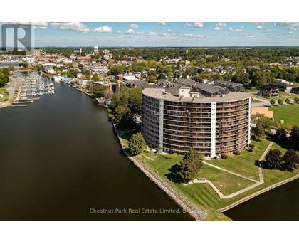 A large building with a curved top is situated next to a body of water.