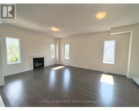 A spacious room with a fireplace and large windows.