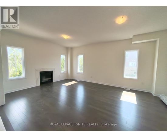 A spacious room with a fireplace and large windows.
